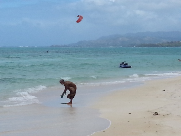 This chap is doing his laundry as kite surfers enjoy the wind blast